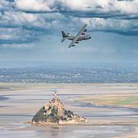 Ein Flugzeug fliegt über die Insel Mont-Saint-Michel.