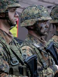 Drei angetretene Soldaten mit Tarnschminke