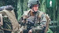 Ein Soldat im Gefechtsanzug steht in einem Wald