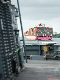 Blick auf eine Containerschiff von einem grauen Schiff aus