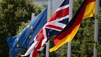 Die Flaggen von Deutschland, Großbritannien und Europa wehen nebeneinander am Mast