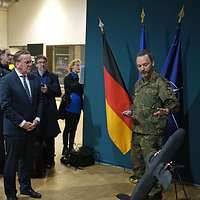 Ein Soldat steht neben einer Drohne und erklärt etwas. Boris Pistorius und weitere Personen hören zu.