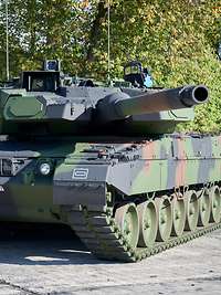 Ein Kampfpanzer vom Typ Leopard 2 A7A1 mit Trophy-System steht auf einer asphaltieren Fläche