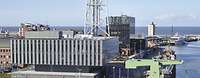 Blick auf einen Hafenbereich mit Schiff, Brücke und Gebäuden