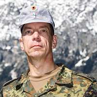 Ein Soldat mit einer grauen Gebirgsmütze schaut freundlich in die Kamera.