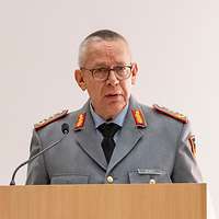 Ein Soldat spricht am Rednerpult vor Publikum