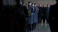 Soldaten tragen Blumenkränzen im Ehrenmal der Bundeswehr, dahinter Pistorius und weitere Personen