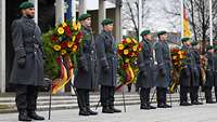 Soldaten stehen mit ausgestellten Blumenkränzen vor dem Ehrenmal der Bundeswehr