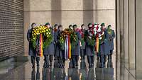 Soldaten tragen große Kränze im Ehrenmal der Bundeswehr 