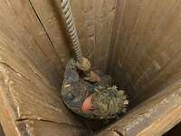 Blick von oben: Ein Soldat seilt sich in einem dunklen Schacht aus Holz ab.