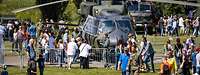 Soldaten und Besucher stehen am Hubschrauber NH-90 auf einem Gelände am Tag der Bundeswehr