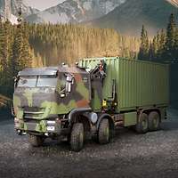 leicht seitlich zu erkennen der IVECO Trakker GTF 8x8, im Hintergrund ist ein Tannenwald.