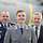 An elderly man and two soldiers stand together in front of an Airbus A400M