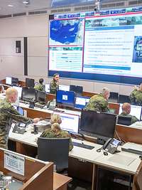 Several military personnel in an operations centre