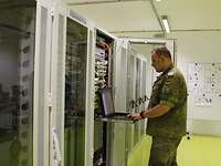 Serverschränke Ein Soldat steht vor den Serverschränken und überprüft die Funktion der Anlage.