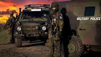 Soldaten stehen an einem Feldjägerfahrzeug und beobachten die Umgebung
