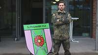 Ein Soldat steht vor einem Schild