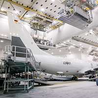 Ein weißes Flugzeug der deutschen Marine steht in einem Hangar.
