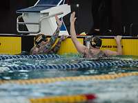 Zwei Sportler am Schwimmbeckenrand geben sich ein High Five