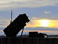 Ein militärisches Raketenstartgerät steht in einer befestigten Stellung im Sonnenuntergang.