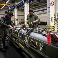 Zwei Soldaten arbeiten an einem Luft-Luft-Lenkflugkörper Meteor in der Transportbox in einer Munitionshalle.