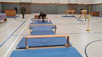 Ein Soldat bewältigt in der Sporthalle verschiedene Hindernisse.
