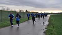 Eine größere Gruppe von Soldaten im Sportanzug joggen gemeinsam.