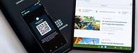 Mappe, Handy mit Code und Tablet mit geöffneten Inhalten