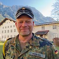 Der KpFw steht vor einem Gebäude im Hintergrund sind Berge zu sehen.