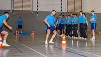 Soldatinnen und Soldaten absolvieren in einer Sporthalle einen Sporttest.