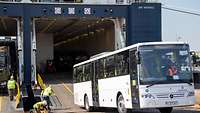 A bus drives out of a ship