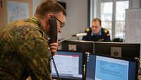 Military personnel on monitors talking on the telephone