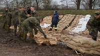 Service personnel putting down sandbags