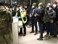 Ukrainische Soldaten stehen in zivil in einer Schlange vor der Kontrolle durch die Bundespolizei