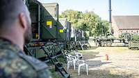 Aufbau der Übungs-Gefechtsstände in Husum Ein Soldat steht vor LKW, die mit Kabinen beladen sind.