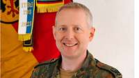 Portrait eines Soldaten vor einer Flagge