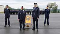 4 Soldaten stehen vor einer Formation angetretener Soldaten.