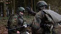 Zwei Soldaten knien im Wald.