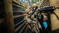Zwei Soldaten beim Kampf durch einen Schützengraben. Einer von beiden wirft eine Übungshandgranate.
