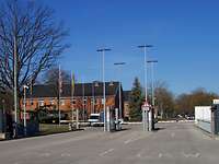 Blick auf eine mehrspurige Ein- und Ausfahrt mit Schlagbaum und Metalltoren