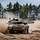 Ein Kampfpanzer Leopard 2A7V fährt im Gelände und wirbelt Staub auf
