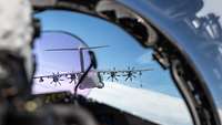 Durch das Cockpit-Fenster eines Eurofighters ist ein Transportflugzeug vom Typ A400M zu sehen.