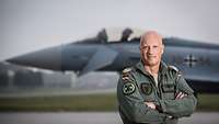 Ein Soldat in Fliegermontur steht vor einem Eurofighter.