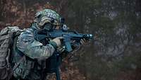 Ein LEKE-Soldat beim Absichern einer Einmündung mit Gewehr G36 im Anschlag.