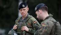 Ein Soldat mit schwarzem Barett blickt entschlossen in die Kamera.