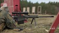 Ein Soldat liegt mit dem Gewehr G82 im Anschlag im Gelände