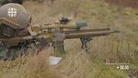Ein Soldat liegt mit dem Zielfernrohrgewehr G28 im Anschlag im Gelände