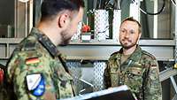 Zwei Soldaten überprüfen ein Großgerät.
