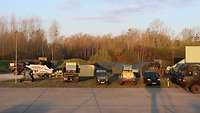 Mehrere militärische Fahrzeuge parken auf einer Freifläche
