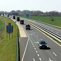 EIne Marschkolonne mit mehreren deutschen Fahrzeugen und einem ungarischen Fahrzeug auf einer Autobahn 